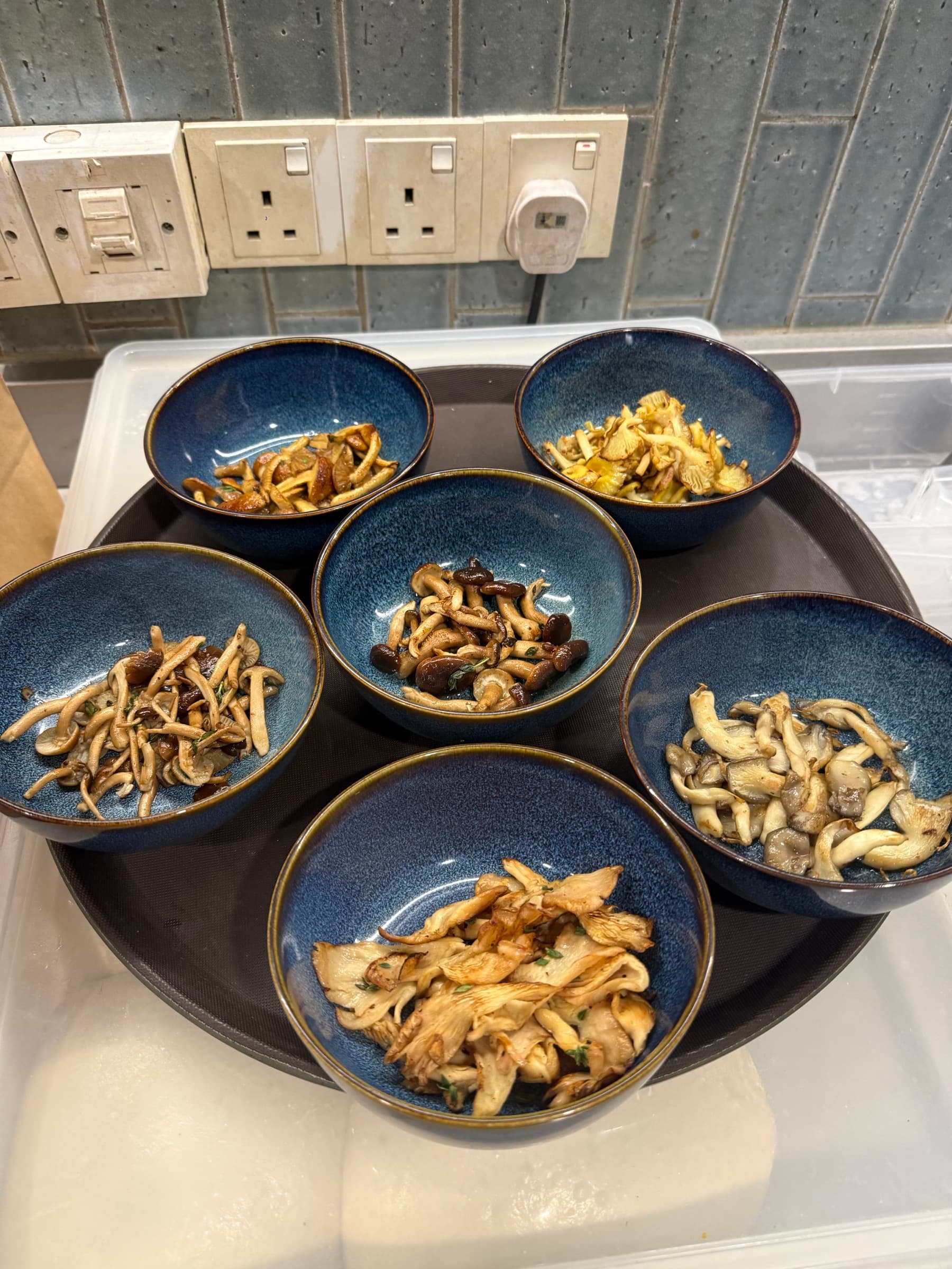 Six bowls of pan-seared Shroomy mushrooms lined up for service