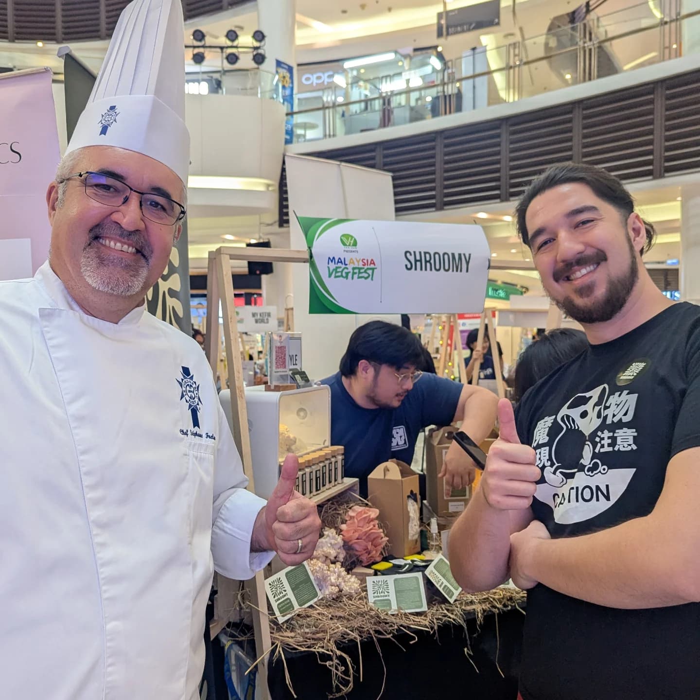 A Le Cordon Bleu Malaysia chef giving a thumbs-up with Shroomy's founder at the Malaysia VegFest booth